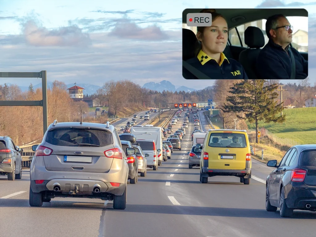 Image illustrating dual HD video surveillance: a forward-facing view of highway traffic and an inset, in-cabin view of a taxi driver and passenger being recorded by a Great Will device.