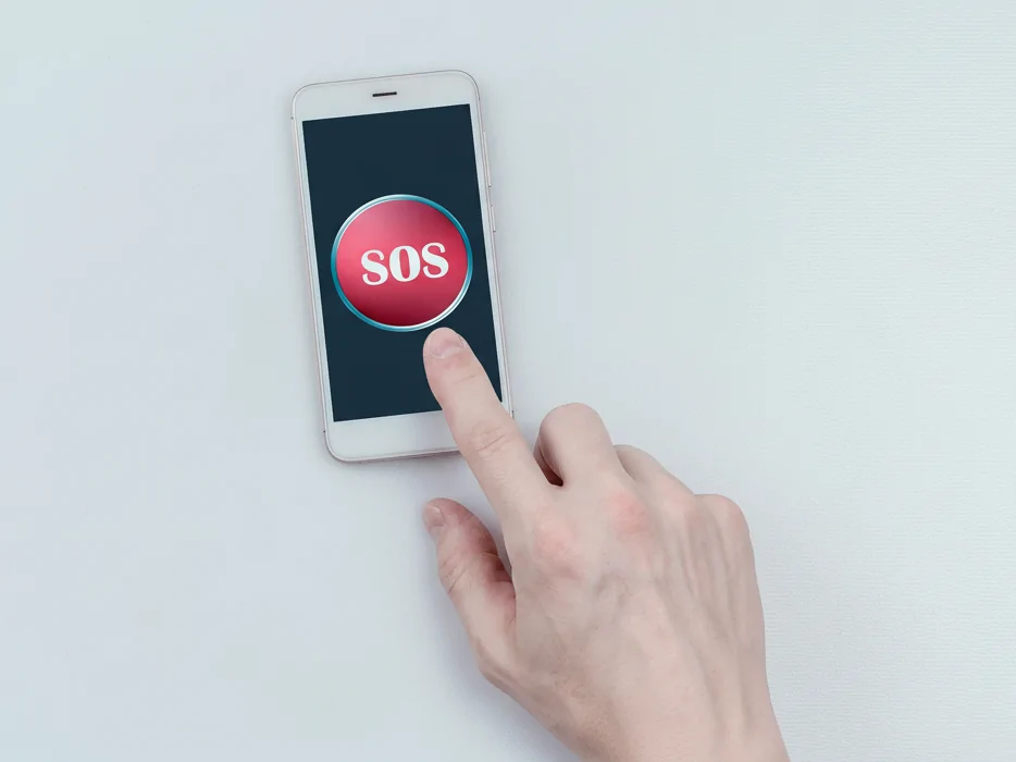 A finger pressing a large red SOS button on a smartphone screen, representing the GT851's emergency alert capability.